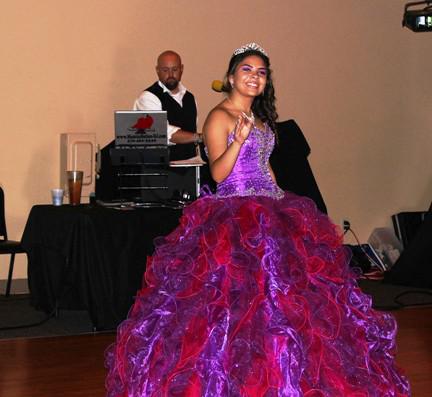 Beautiful young Hispanic girl dressed in a pretty purple sequin dress dances at her Quinceanera at the Event Place in Fayetteville, AR.