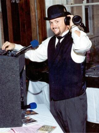 DJ Sean Hearn at a wedding reception mixing in a song, in his formative years, standing in front of the 2200 CDs he took to every party.