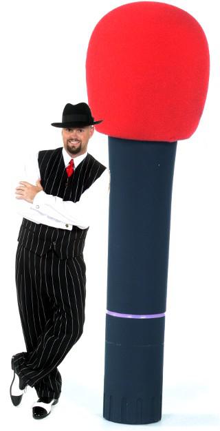 Disk Jockey Sean Hearn appears to be standing beside a life size cordless Shure Microphone. Sean is always dressed for the occasion and in this case is wearing a pin striped zoot suite, black and white spat shoes, a sharp black fedora hat, a bright red tie and a pair of sterling silver gramophone record player cuff links.