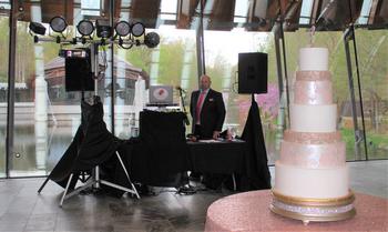 DJSean and his set up positioned behind the wedding cake at Crystal Bridges Museum of American Art in Bentonville Arkansas just as the guests arrive for the wedding reception of Jeremy and Stacie Hurtt.