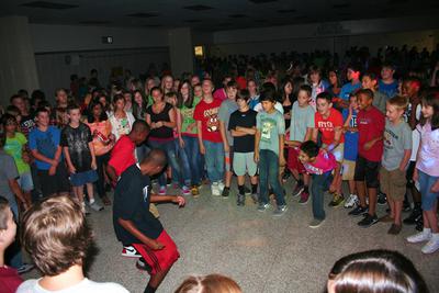 At the Lincoln Junior High Dance in Bentonville, Arkansas, a large crown of students for a circle around two boys as the demonstrate their dance moves to Silento's Watch me (Whip It Nae Nae).