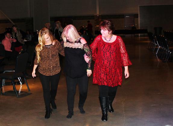 Three women do the Boot Scootin' Boogie at the Shady Point AES Christmas Party held at he Donald W Reynolds Community Center in Poteau Oklahoma.
