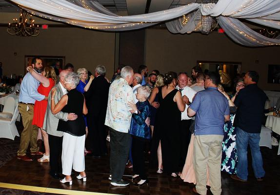 The dance floor is full as the whole group sways to a slow song by DJSean Hearn at a wedding reception held at the Best Western in Eureka Springs.