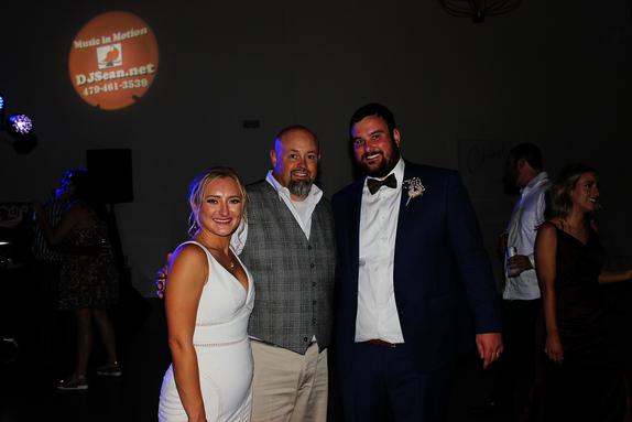 DJSean Hearn poses with the bride and groom at their reception being held at the Osage House in Cave Springs Arkansas.